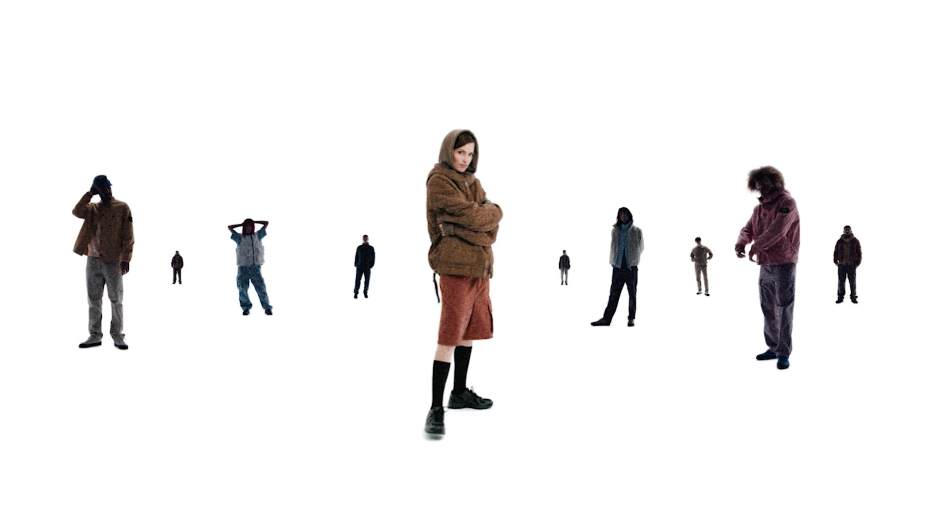 Group of diverse individuals wearing key Stone Island pieces, standing separately